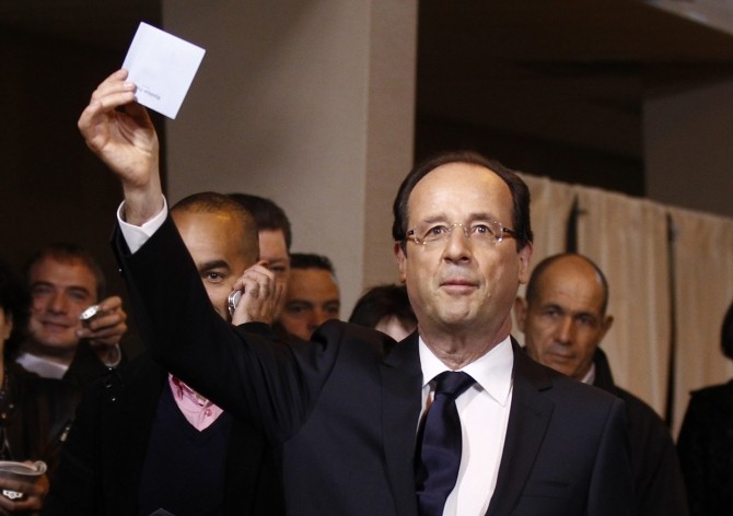 Francois Hollande, Socialist Party candidate for the 2012 French presidential election, holds his ballot in the second round vote of 2012 French presidential election at a polling station in Tulle