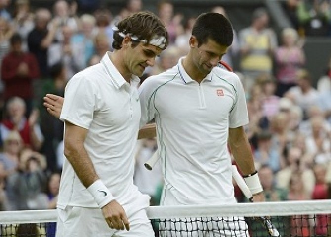 Roger Federer of Switzerland talks to Novak Djokovic of Serbia after defeating him in their men's semi-final tennis match at the Wimbledon tennis championships in London