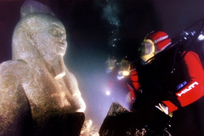 DIVERS INSPECTS A THE STATUE OF THE GOD HAPI OF THE COAST OF ALE