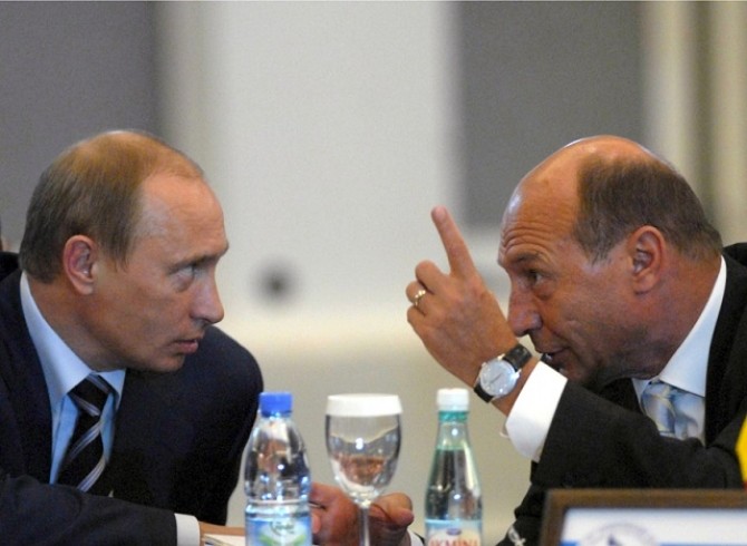 Romanian President Basescu gestures as he talks to Russia's President Putin during the 15th Summit of Black Sea Economic Cooperation Organisation in Istanbul