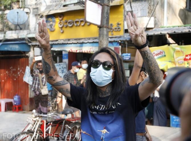 O persoană din Myanmar,  sloganul cu trei degete și strigă sloganul în timp ce protestează împotriva loviturii de stat din Yangon, Myanmar