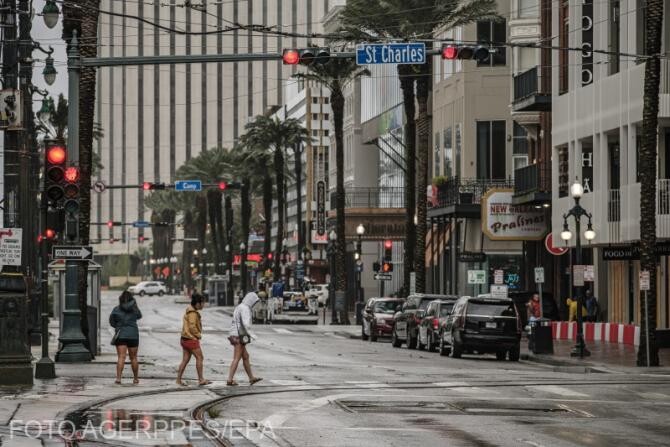 Un grup de femei traversează Canal Street în centrul  New Orleans, Louisiana, SUA, 29 august 2021, în așteptarea uraganului Ida. Uraganul Ida  are loc la aniversarea a 16 ani a uraganului Katrina. 