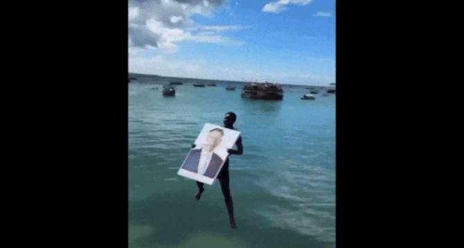 Ceremonie neobișnuită în Tanzania. Localnicii au sărit cu tabloul lui Klaus Iohannis în apă, strigând "Hakuna matata!" / Foto: Captură video Digi24